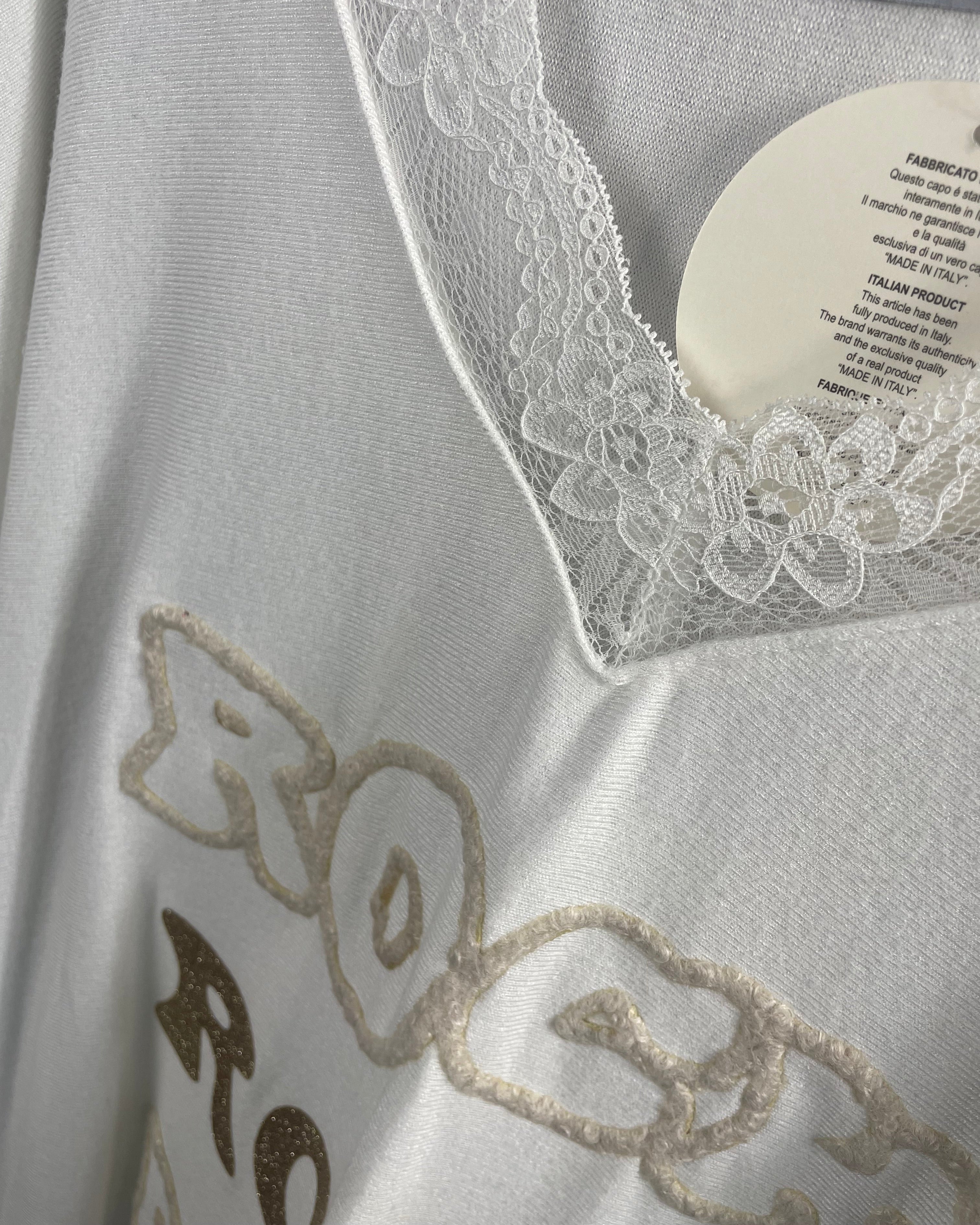 Détail du col dentelle et motif pailleté “ROCK” sur fond doux.