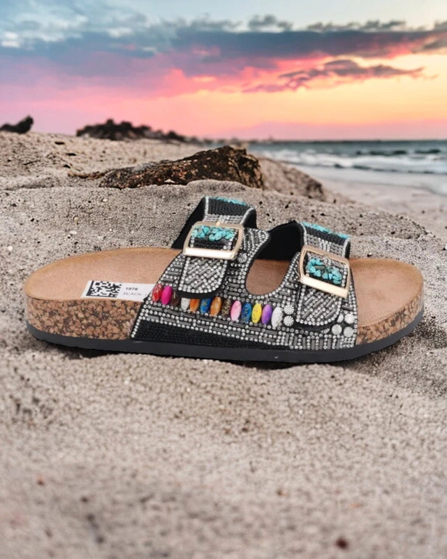 Gros plan brides ajustables avec strass et pierres colorées sur mules bohème noires