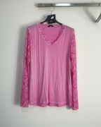 Top rose vif en dentelle ajourée, mis en valeur par une lumière naturelle douce