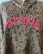 Détail paillettes dorées poignets sweat California rose fluo oversize