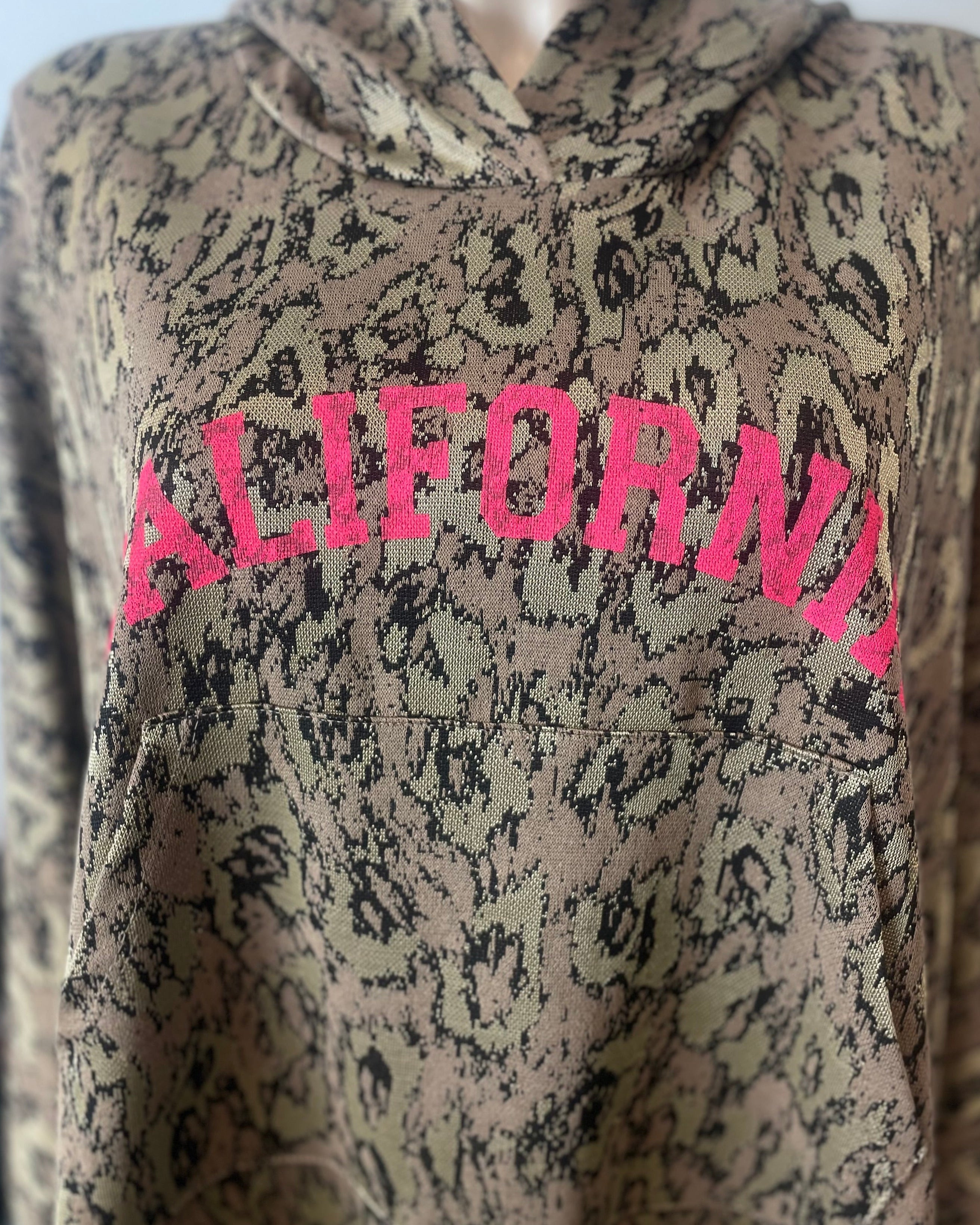 Détail paillettes dorées poignets sweat California rose fluo oversize