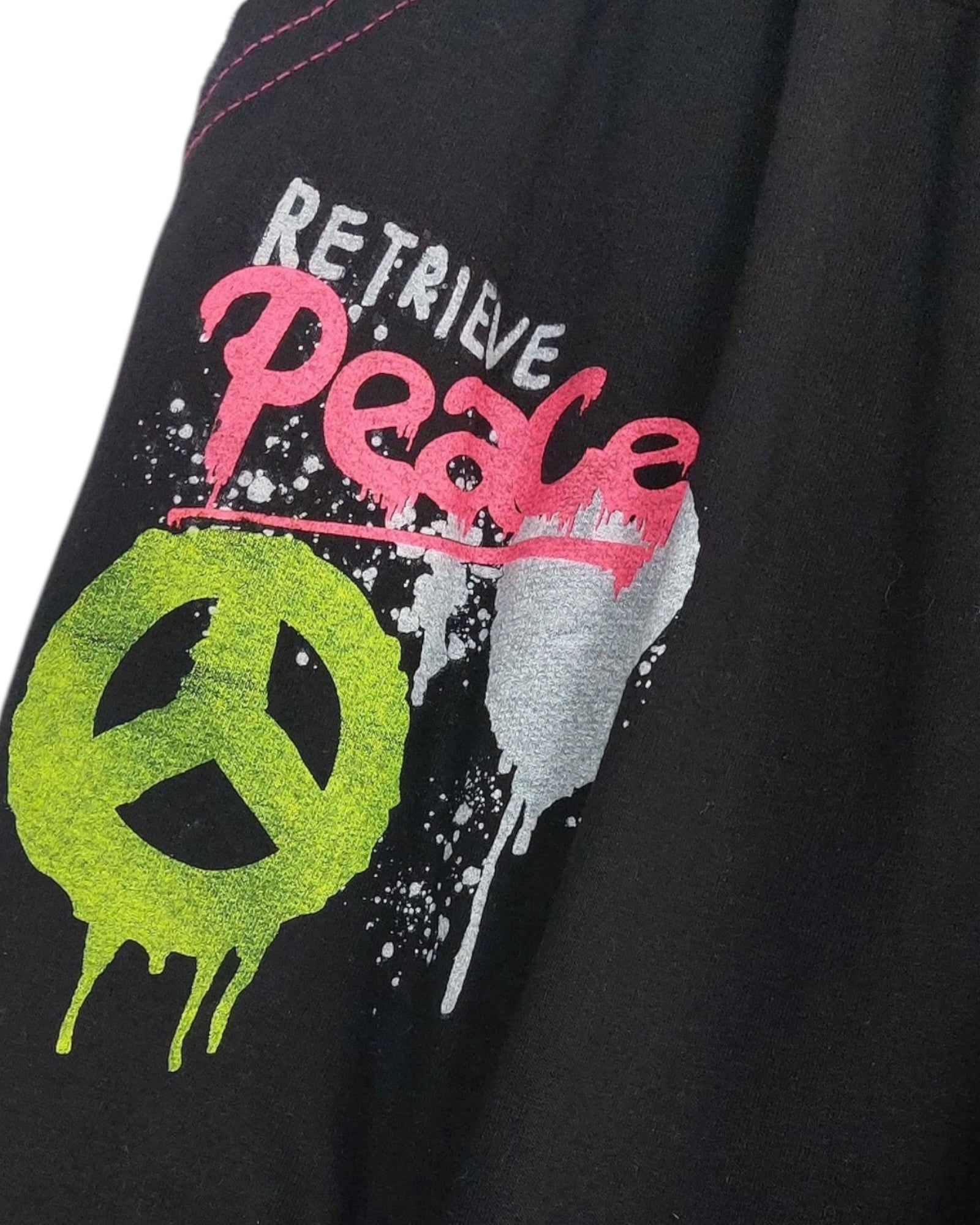 Détail du logo peace fluo sur le jogging saouel 'Retrieve Peace