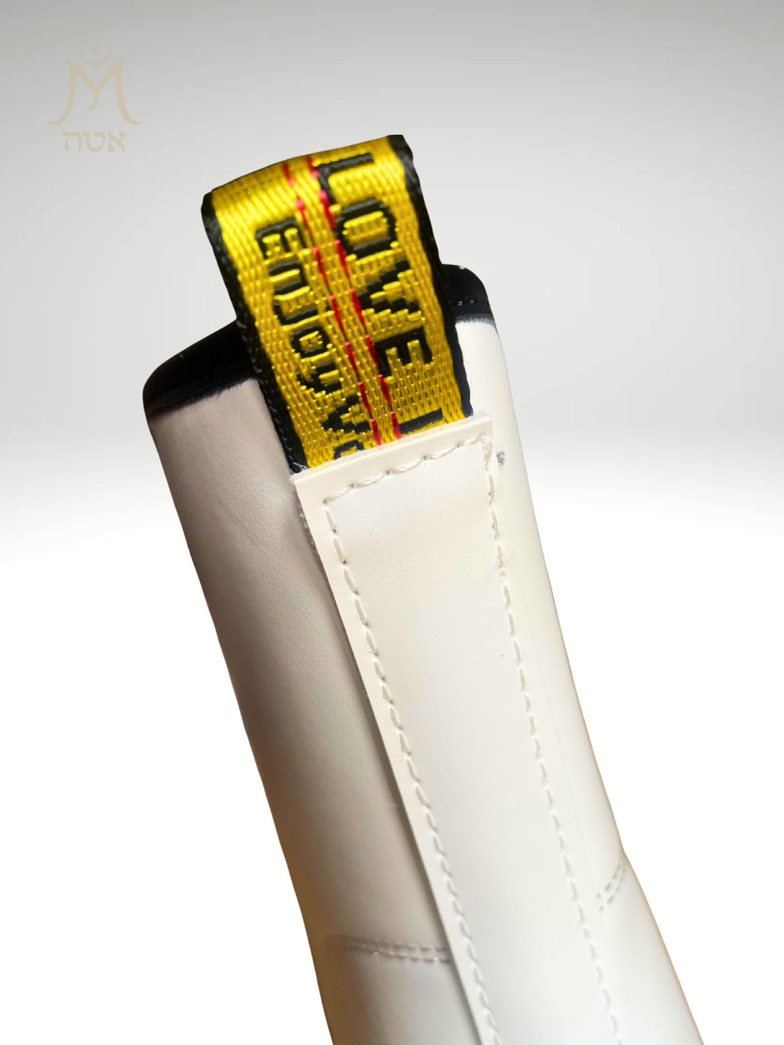 détail languette jaune Love Enjoy à l’arrière de la bottine blanche