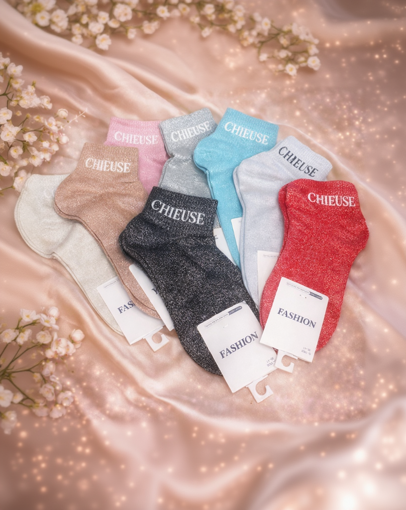 Vue d’ensemble de 10 paires de chaussettes pailletées en dégradé de couleurs, toutes avec inscription “CHIEUSE”.
