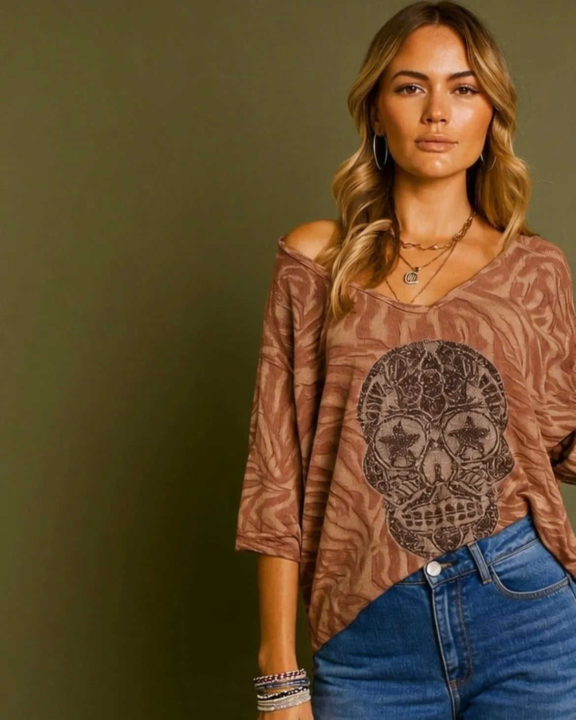 Femme portant un pull vieux rose à tête de mort scintillante, manches longues, style rock chic