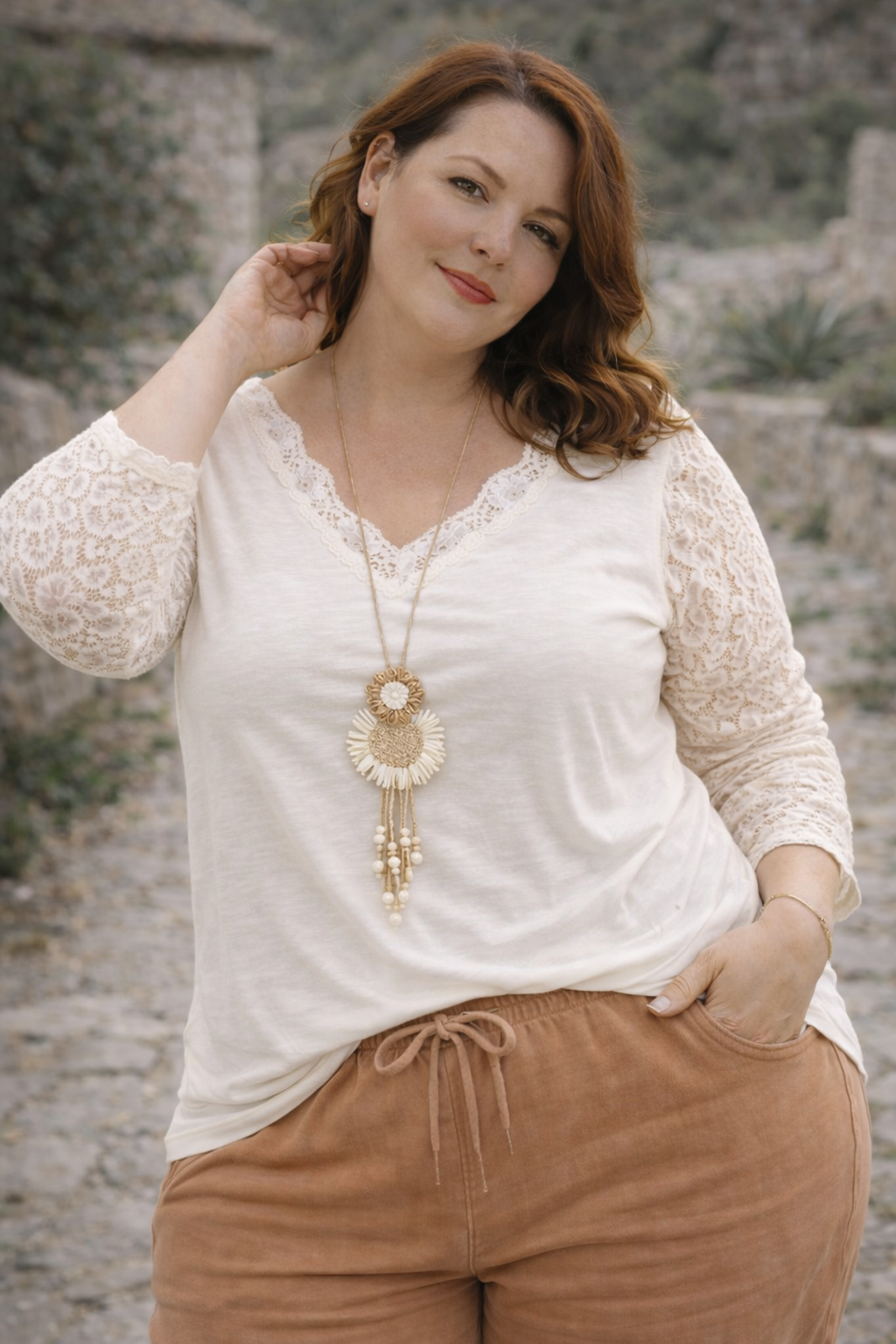 Top blanc en dentelle ajourée, look doux et féminin, mi-corps femme souriante