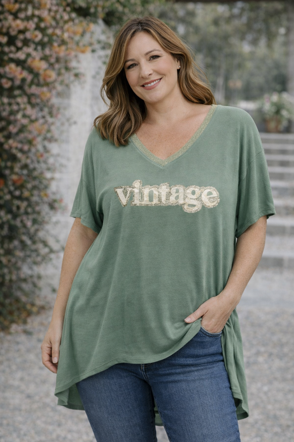 T-shirt kaki “Vintage” col V pailleté suspendu, lumière naturelle et déco murale bohème.