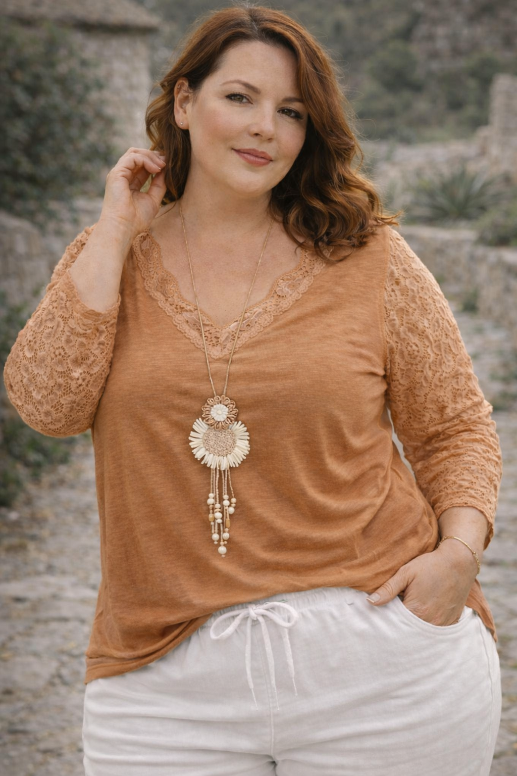 Top camel en dentelle ajourée, look doux et féminin, mi-corps femme souriante