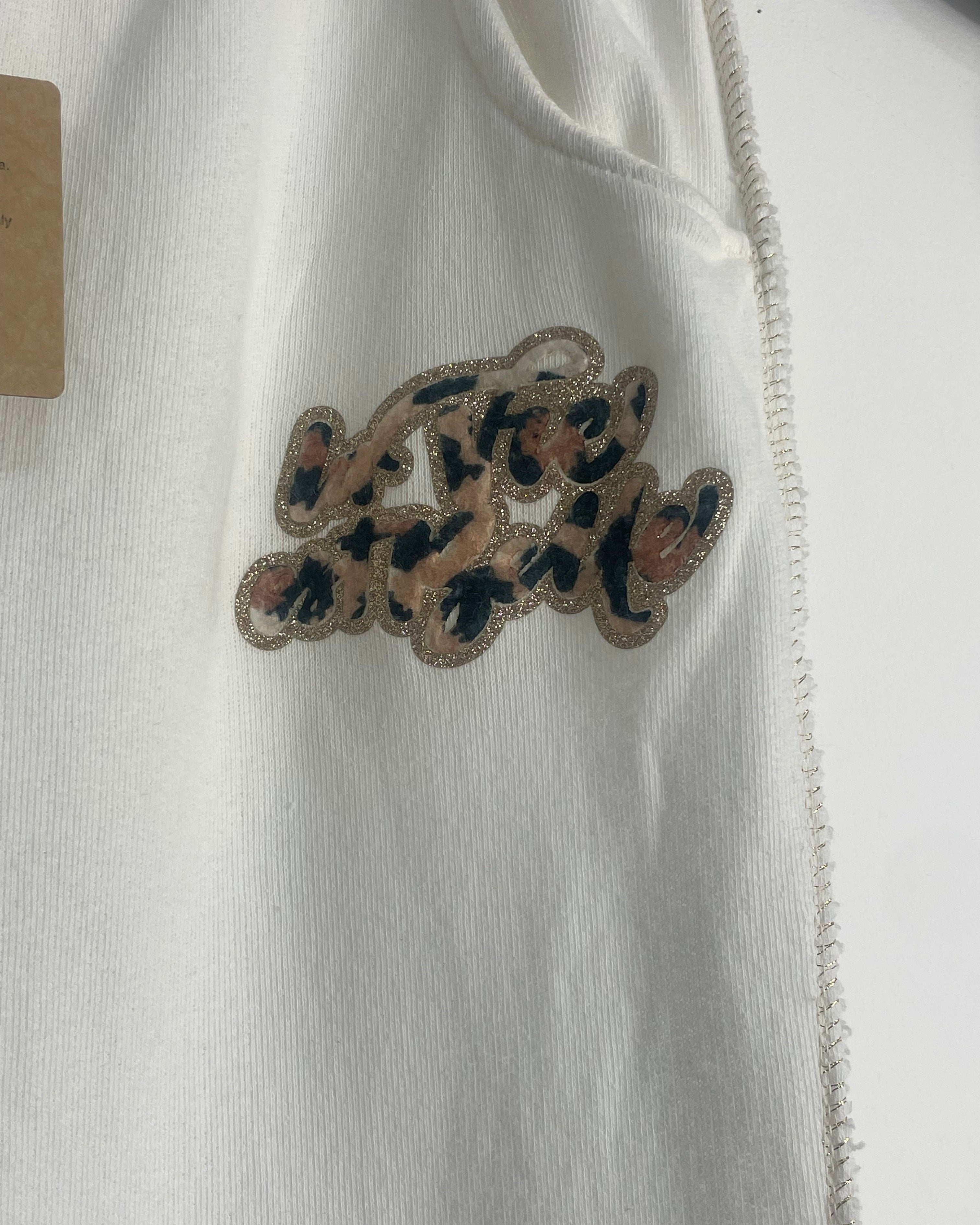 Détail inscription léopard La Vie Est Belle sur jogging grande taille beige avec coutures dorées