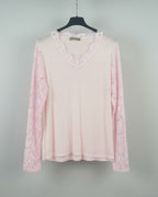 Top rose pâle en dentelle ajourée, look doux et féminin, mi-corps femme souriante