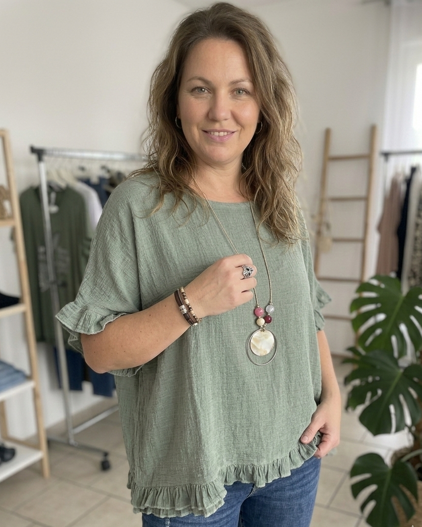 Look bohème chic femme 40 ans : blouse fluide kaki à manches volantées et jean brut.