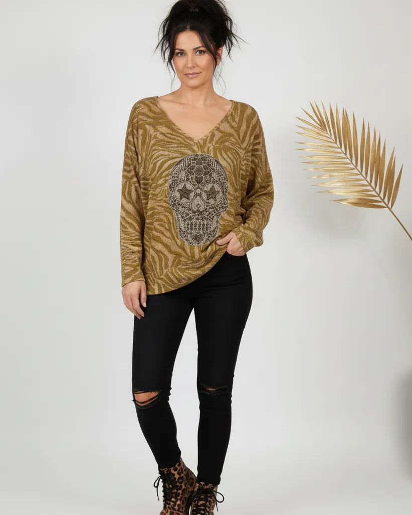 Femme portant un pull moutarde à tête de mort scintillante, manches longues, style rock chic