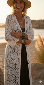 Gros plan sur la maille délicate d'un gilet bohème blanc cassé, focus sur la texture du vêtement et les finitions de qualité.