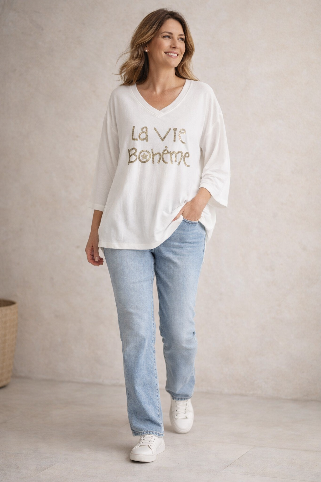 Pull blanc femme col V “La Vie Bohème” doré, coupe fluide, porté avec jean clair et sneakers blanches