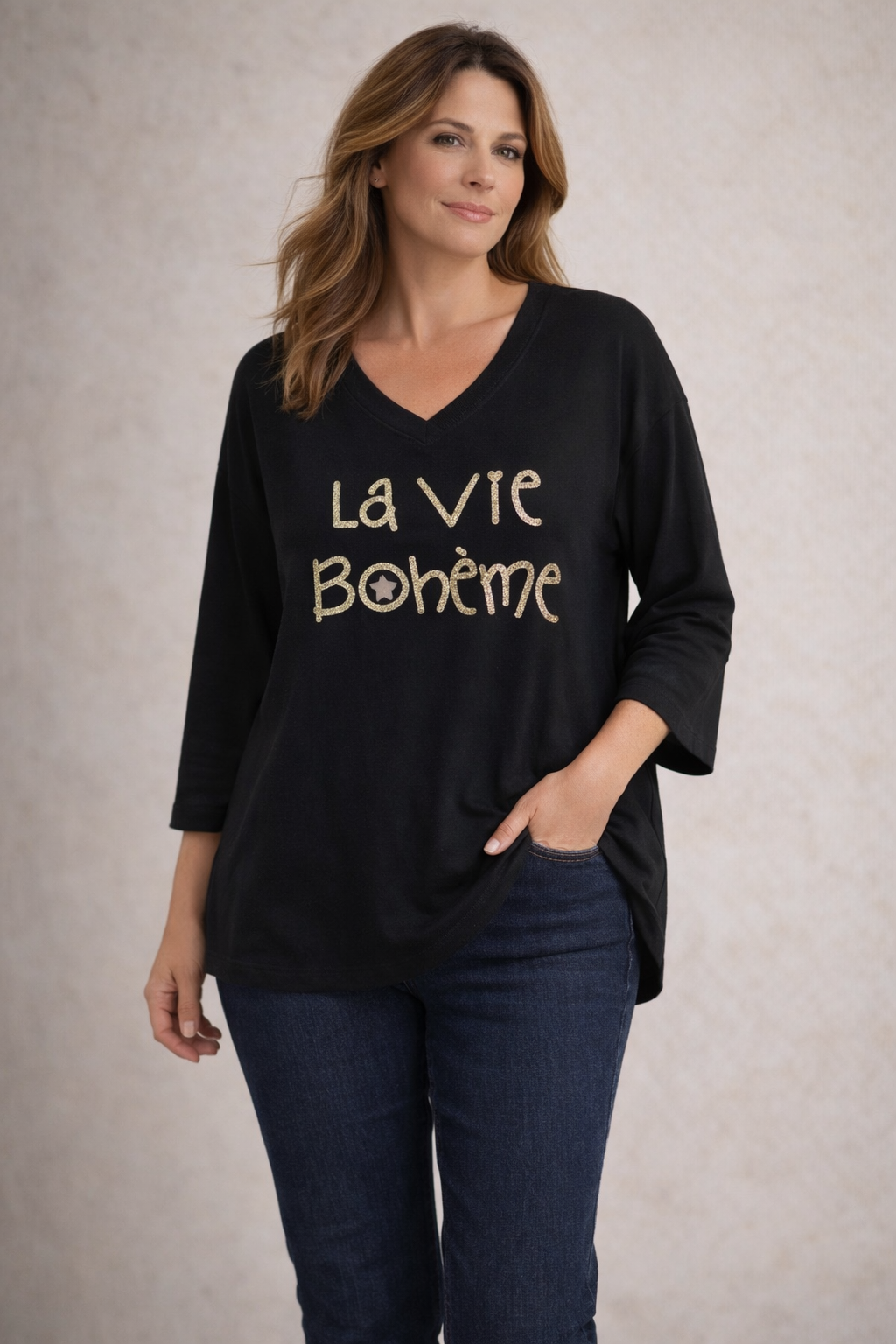 Pull noir femme col V La Vie Bohème doré, porté avec jean brut foncé
