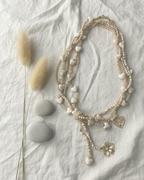 Sautoir bohème multi-rangs perles bois et nacre 55cm, vue d'ensemble sur fond lin