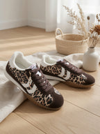Baskets léopard femme style rétro, pose lifestyle moderne sur bois clair – sneakers fourrure et charm LOVE