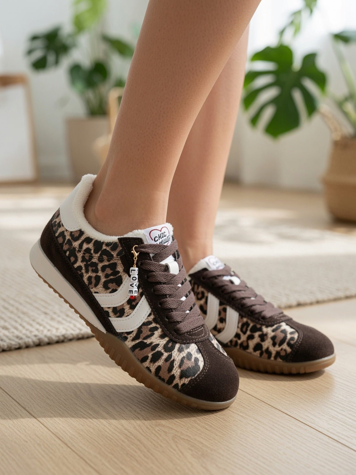 Baskets léopard femme style rétro, pose lifestyle moderne sur bois clair – sneakers fourrure et charm LOVE