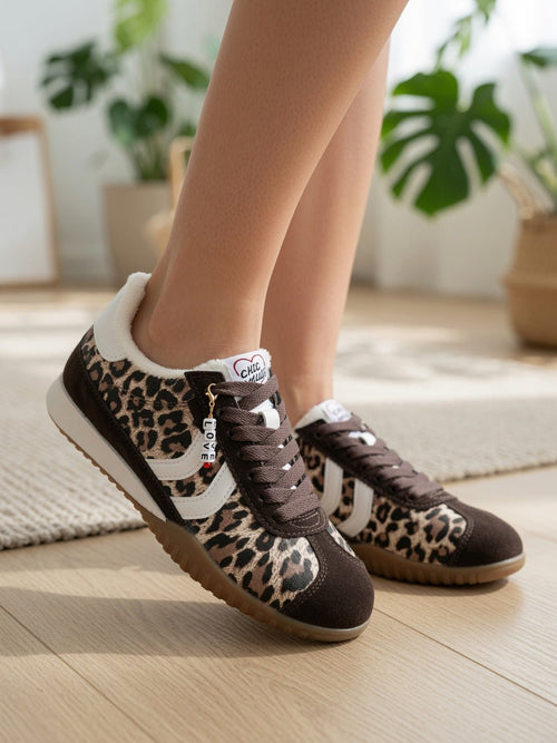 Baskets léopard femme style rétro, pose lifestyle moderne sur bois clair – sneakers fourrure et charm LOVE
