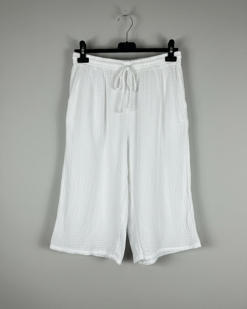 Bermuda gaze de coton blanc sur cintre, silhouette évasée et légère, taille élastique avec cordon