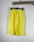 Bermuda gaze de coton jaune citron sur cintre, coupe évasée et légère, couleur solaire et estivale grande taille