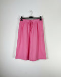 Bermuda gaze de coton rose bonbon sur cintre, silhouette évasée et légère, taille élastique avec cordon