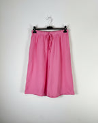 Bermuda gaze de coton rose bonbon sur cintre, silhouette évasée et légère, taille élastique avec cordon