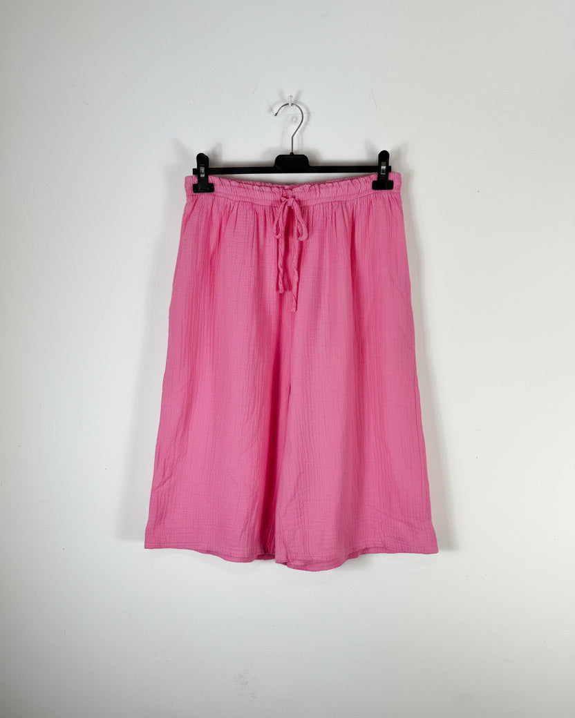 Bermuda gaze de coton rose bonbon sur cintre, silhouette évasée et légère, taille élastique avec cordon