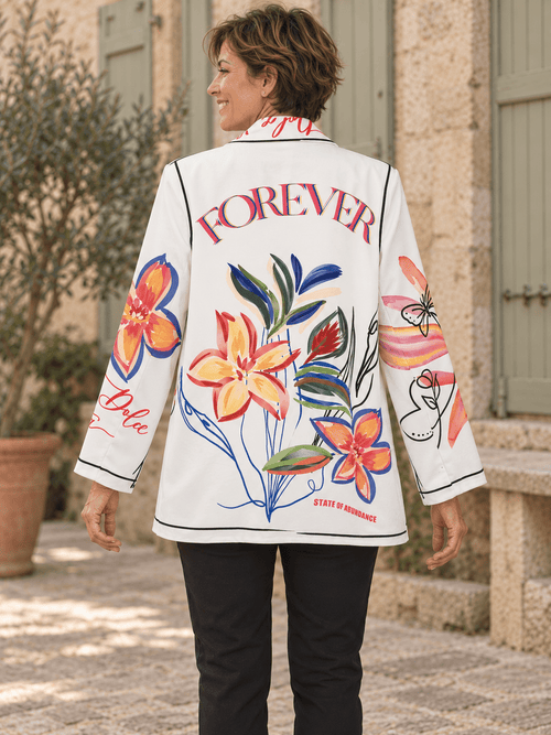 Dos du blazer Forever porté, avec grande inscription colorée et fleurs sur fond blanc.