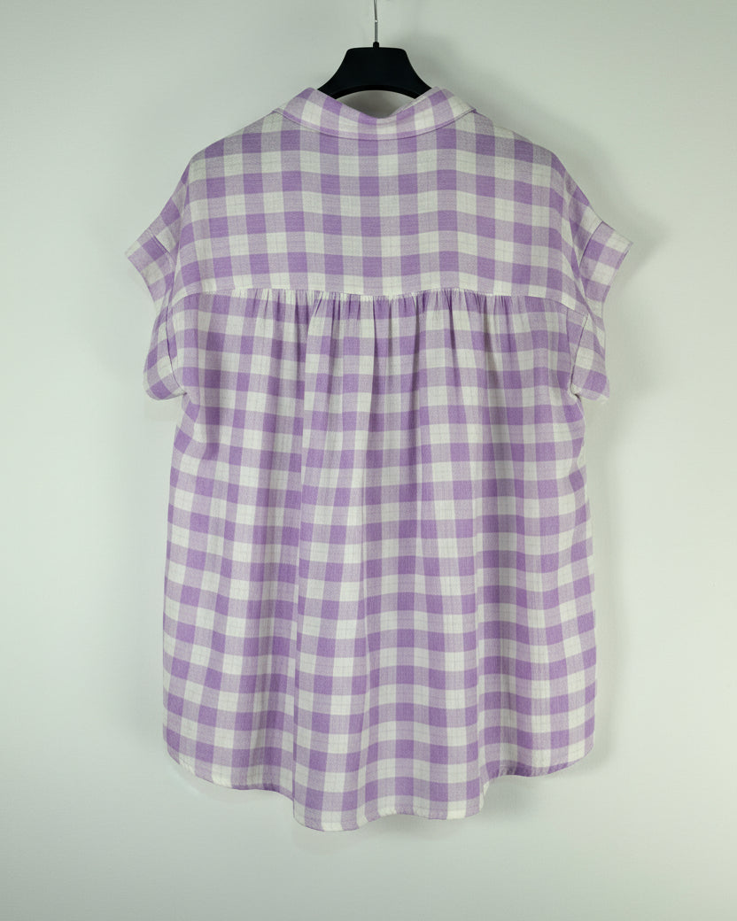 Blouse vichy lavande et blanc vue de dos sur cintre, empiècement froncé dans le dos, coupe trapèze grande taille
