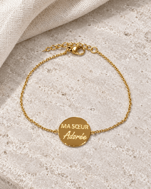 Vue retouchée du bracelet doré Ma sœur adorée, gravure et chaîne sur pierre claire.