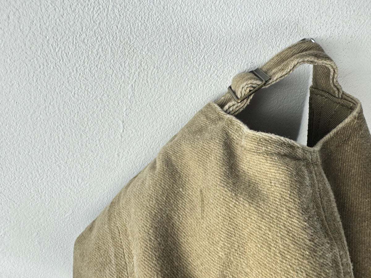 Détail de la patte en coton et de la boucle métallique de réglage sur une casquette camel.