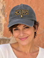 Casquette Chieuse en jean gris délavé portée par une femme aux cheveux courts, cadrage tête-épaules.
