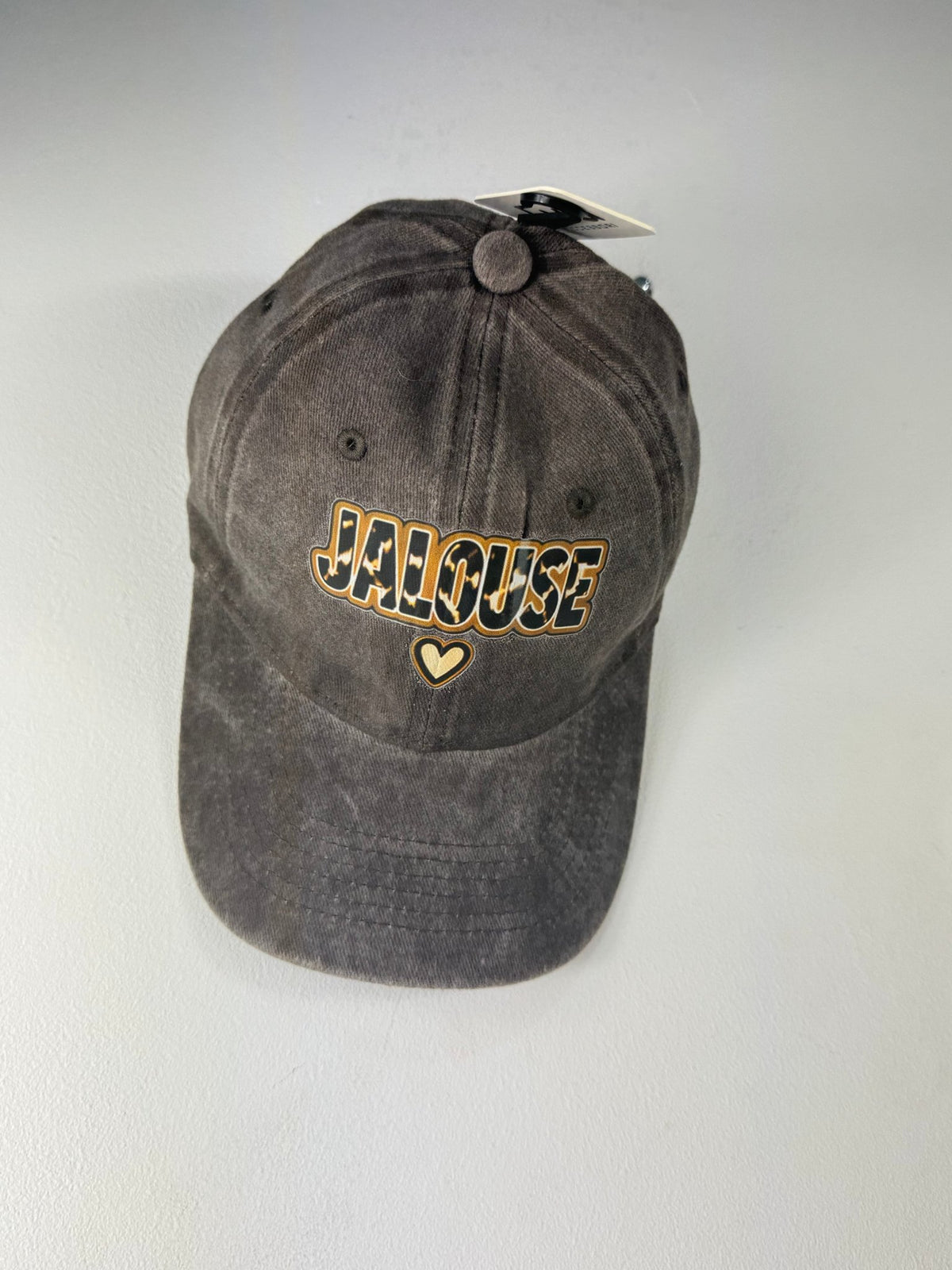 Casquette Jalouse noir délavé avec cœur sous le message, vue de face.