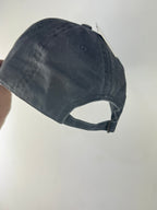 Arrière de la casquette en jean gris délavé, patte réglable et boucle métallique.