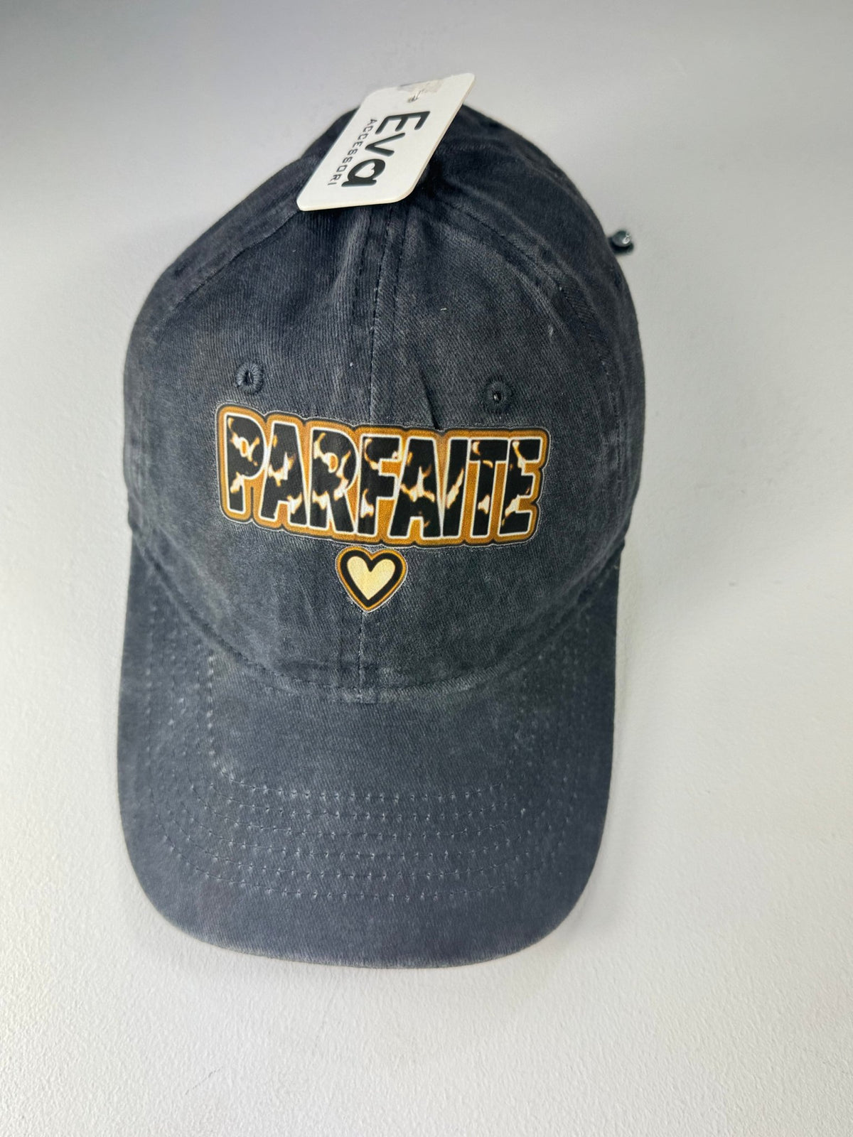Casquette Parfaite en jean noir délavé avec petit cœur sous le message, photo boutique.