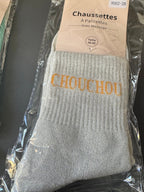Chaussettes CHOUCHOU blanches à message jaune, dans leur emballage.