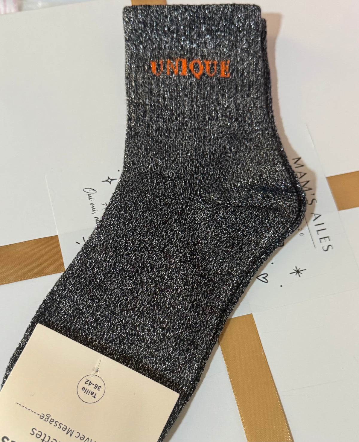 Chaussette UNIQUE noire à fils argentés et message orange, détail réel