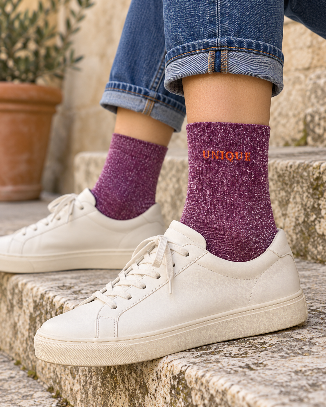 Chaussettes UNIQUE violettes portées avec un jean retroussé et des baskets écrues
