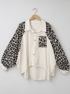 Chemise blanche sur cintre, manches et poche léopard, coupe évasée et bas arrondi.