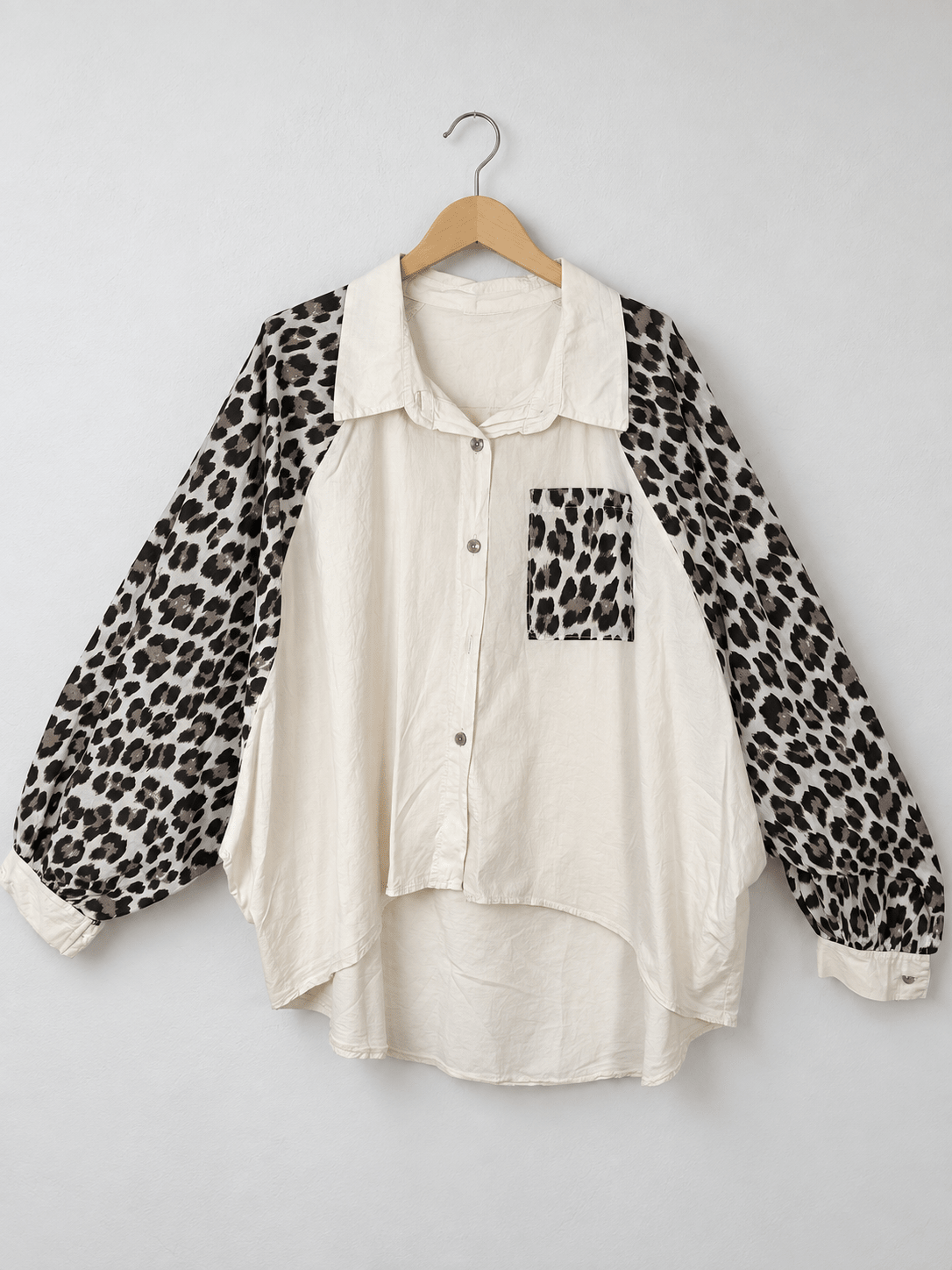 Chemise blanche sur cintre, manches et poche léopard, coupe évasée et bas arrondi.