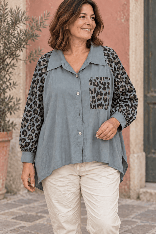 Femme portant la chemise bleu gris aux manches et à la poche léopard avec un pantalon écru.