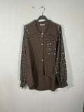 Chemise chocolat sur cintre, col uni, manches et poche poitrine léopard.