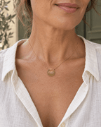 Collier doré Les copines c’est la vie porté au décolleté, vue rapprochée.