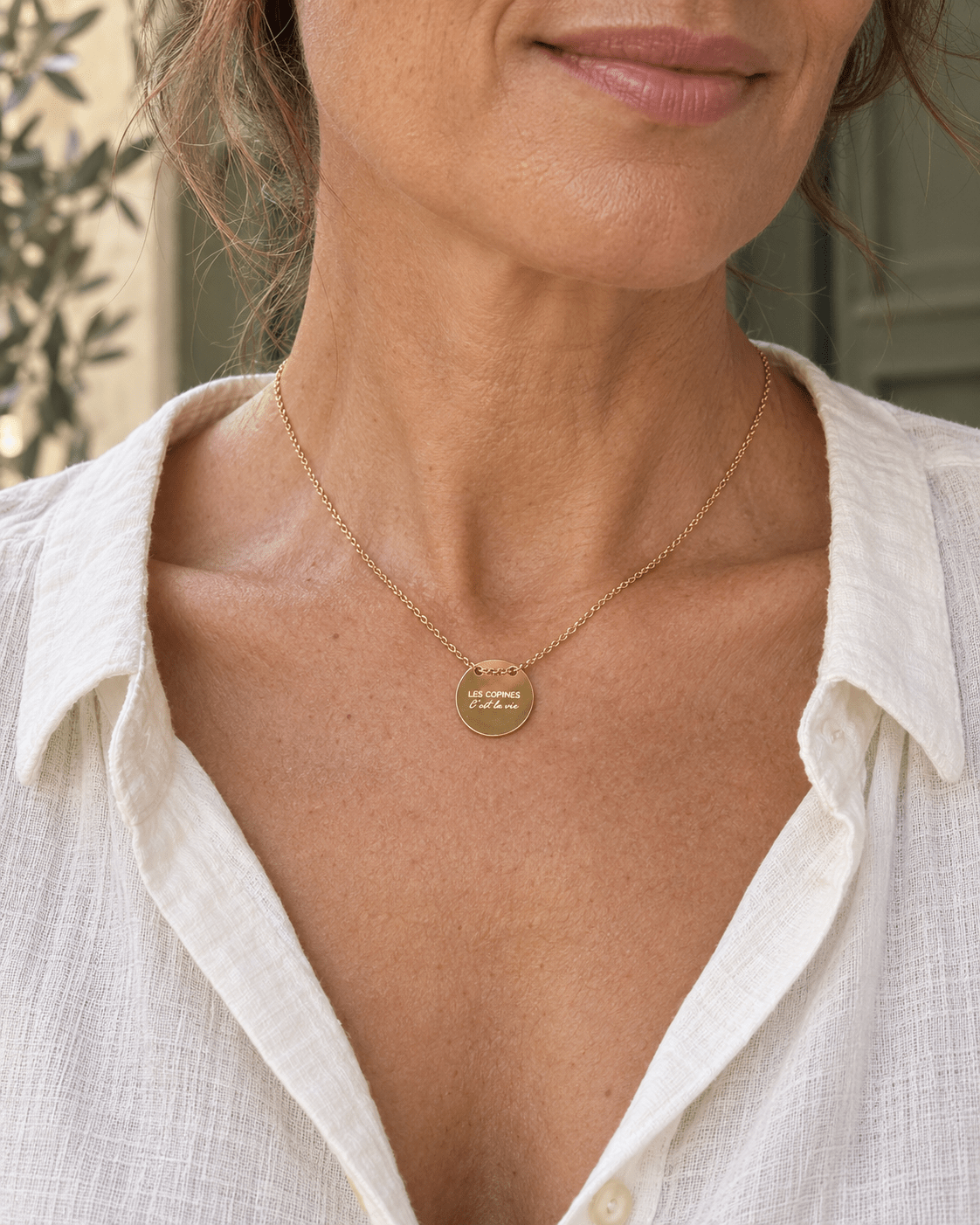 Collier doré Les copines c’est la vie porté au décolleté, vue rapprochée.
