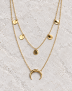 Vue retouchée du collier doré à deux rangs, cinq pastilles rondes et lune sur pierre claire.