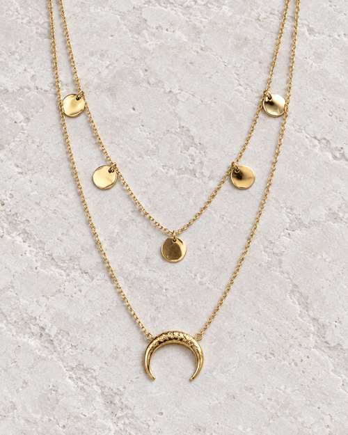 Vue retouchée du collier doré à deux rangs, cinq pastilles rondes et lune sur pierre claire.