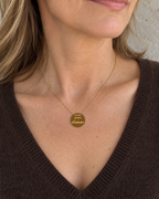 Collier doré Maman d’amour porté au décolleté avec une maille chocolat.