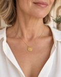 Collier court Mamie en or porté dans l’encolure d’une chemise ivoire.