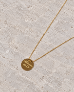 Vue retouchée de la médaille Marraine en or sur pierre claire, gravure visible.